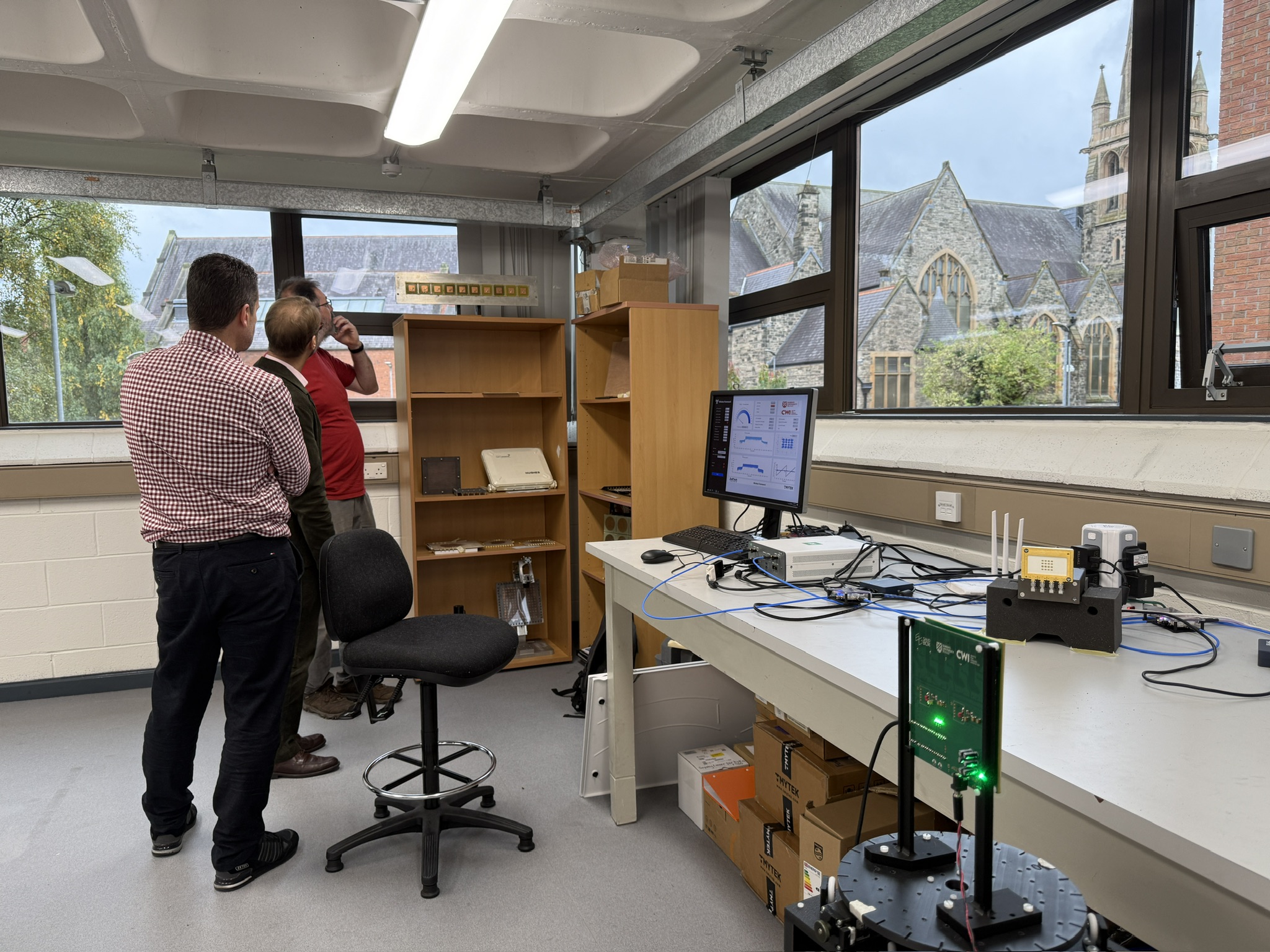 Researchers discussing the RIS-assisted communication setup in the Keysight Lab